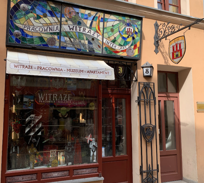 Витражная лавка. Над входом висит герб Торуни.