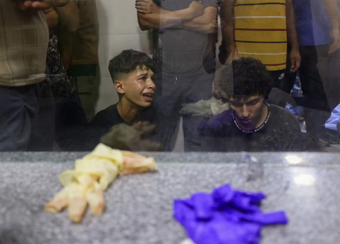 Палестинская молодежь оплакивает смерть своего родственника, погибшего в результате израильского обстрела в центре распределения продовольствия Гуманитарного фонда Газы на улице Салахеддин.