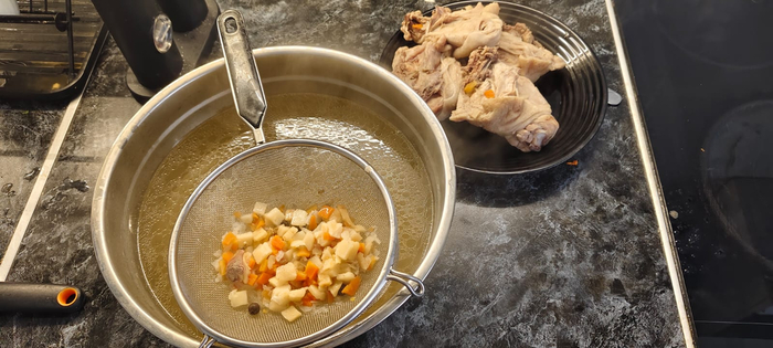 Когда бульон готов, вылавливаю обрезки от крыльев ( их сразу в мусор), достаю бедрышки , процеживаю бульон через сито.