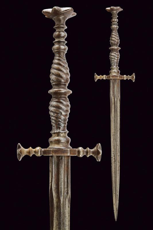 Длина 28,2 см. Прямой клинок с мощным центральным ребром. Железные рукоять и навершие со звездообразными наконечниками.