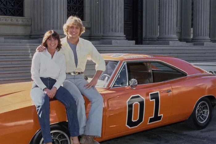 Американский актёр и певец Джон Шнайдер и журналистка из Tiger Beat, сидят на автомобиле Dodge Charger General Lee, из телесериала CBS Придурки из Хаззарда, в которой Шнайдер сыграл главную роль. США, январь 1981 года. Фото из Архива Майкла Окса. Американский актёр и певец Джон Шнайдер и журналистка из Tiger Beat, сидят на автомобиле Dodge Charger General Lee, из телесериала CBS Придурки из Хаззарда, в которой Шнайдер сыграл главную роль. США, январь 1981 года. Фото из Архива Майкла Окса.