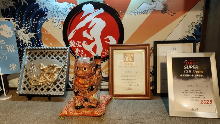 Встречает нас на втором этаже полочка с сертификатами о том, что пиво подаётся тут как надо. И посмотрите какой забавный талисман-кошка, первый раз такой узорчатый вижу.