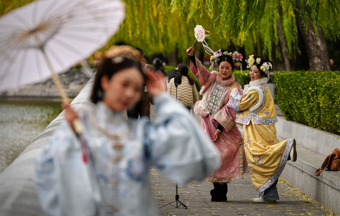 Девушки в традиционных нарядах фотографируются возле Запретного города в Пекине//Фото: АР/ТАСС