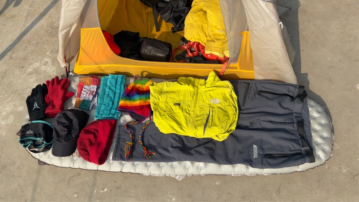 Разная одежда. Штаны теплые, купленные в Непале, ветровка, две шапки две пары перчаток, баф Мега универсальный полотенце и минигамаши от пыли и камней на кроссовки.